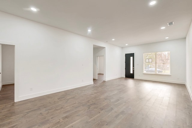 spare room featuring baseboards, wood finished floors, and recessed lighting