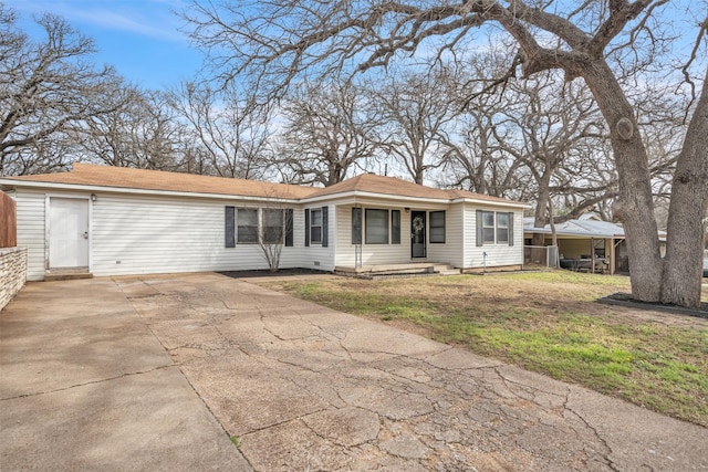 ranch-style home featuring concrete driveway and a front yard