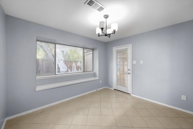 tiled empty room with a chandelier, visible vents, and baseboards