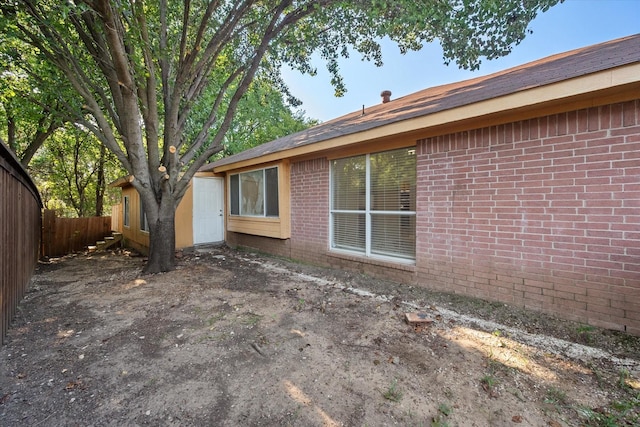 back of property with brick siding and fence