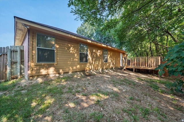 view of property exterior featuring fence and a deck