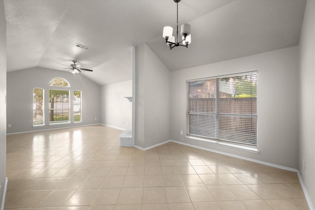 empty room featuring lofted ceiling, light tile patterned floors, ceiling fan with notable chandelier, visible vents, and baseboards