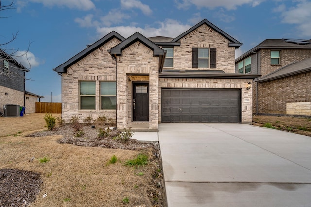 view of front of house with central AC unit, a garage, brick siding, fence, and concrete driveway