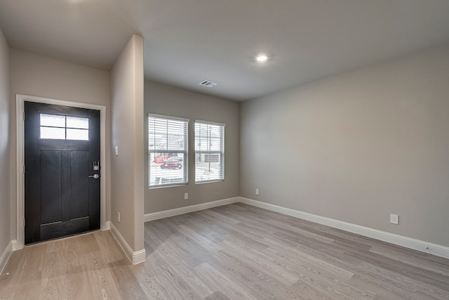 foyer entrance with baseboards, visible vents, plenty of natural light, and light wood finished floors