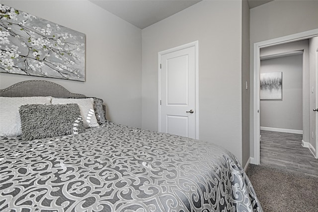 bedroom with baseboards and wood finished floors