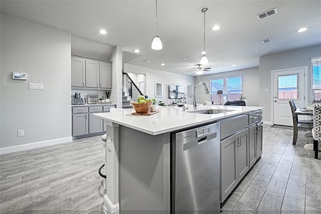 kitchen featuring a sink, visible vents, stainless steel dishwasher, and gray cabinets