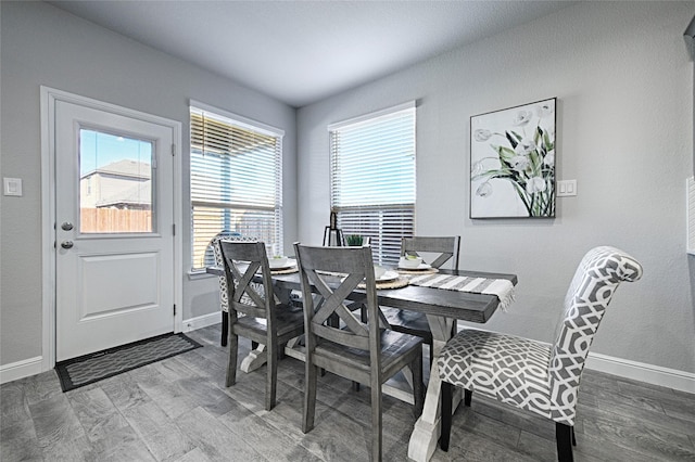 dining space featuring baseboards and wood finished floors