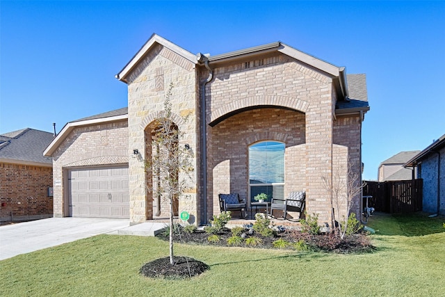 french country style house with stone siding, an attached garage, driveway, and a front yard