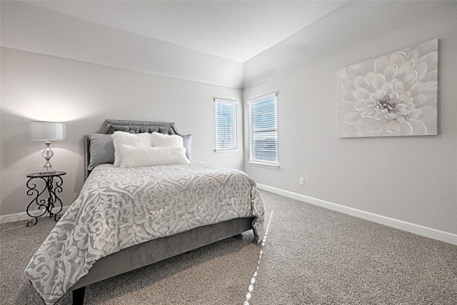 carpeted bedroom featuring baseboards and lofted ceiling