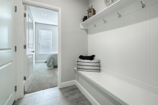 mudroom with wood finish floors, visible vents, baseboards, and a textured ceiling