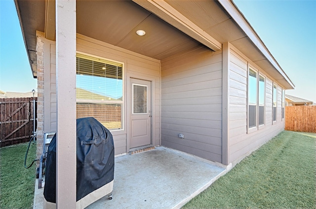 entrance to property featuring a yard and fence