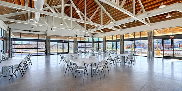 unfurnished dining area with high vaulted ceiling and concrete floors