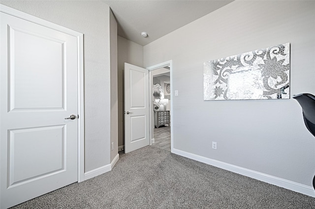 unfurnished bedroom featuring carpet flooring and baseboards