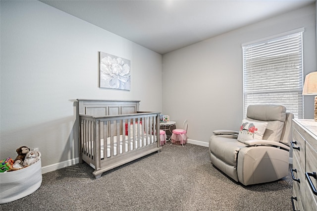 bedroom featuring a crib, carpet flooring, and baseboards