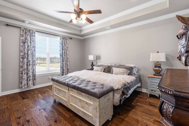 bedroom with ornamental molding, dark wood-style flooring, a raised ceiling, and visible vents