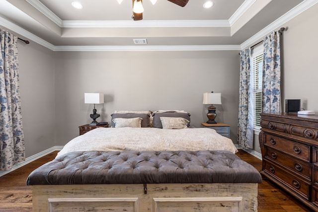 bedroom with ornamental molding, dark wood-style flooring, a raised ceiling, and visible vents