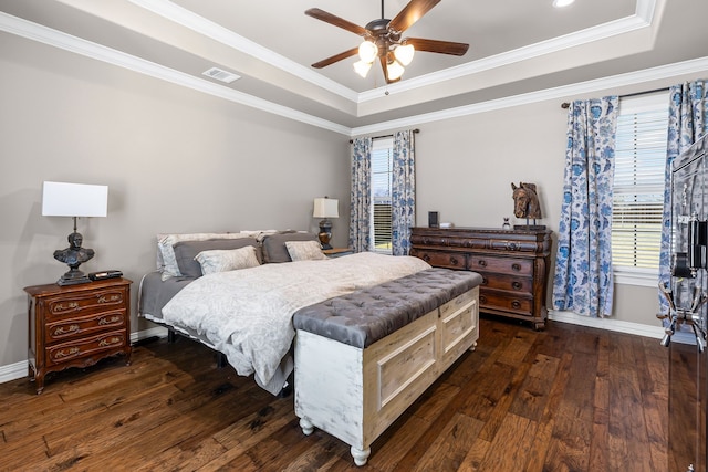 bedroom featuring dark wood-style floors, a tray ceiling, and ornamental molding