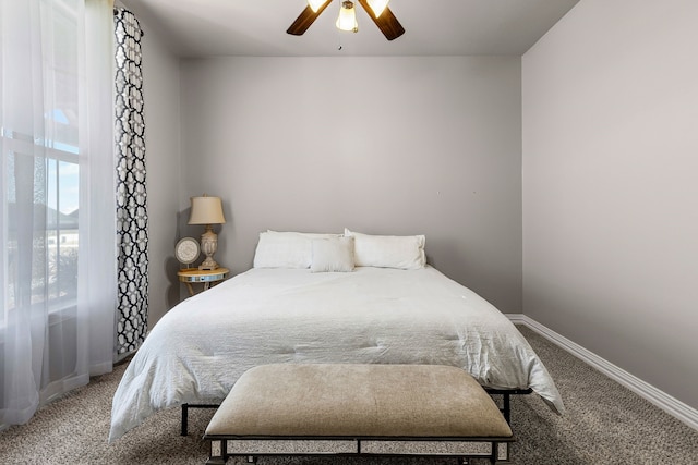 carpeted bedroom with ceiling fan and baseboards