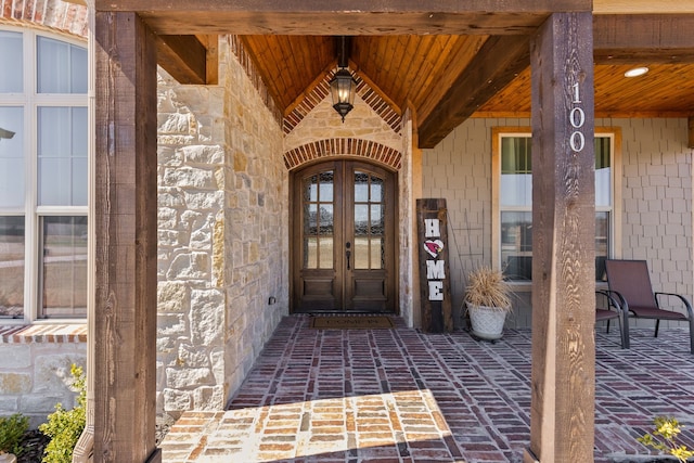 property entrance featuring stone siding and french doors