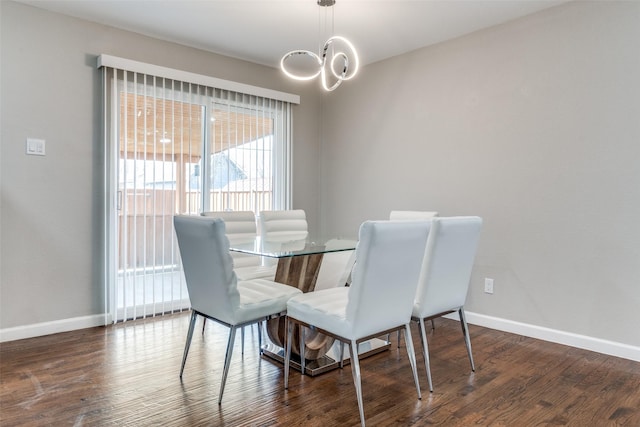 dining room with a chandelier, baseboards, and wood finished floors