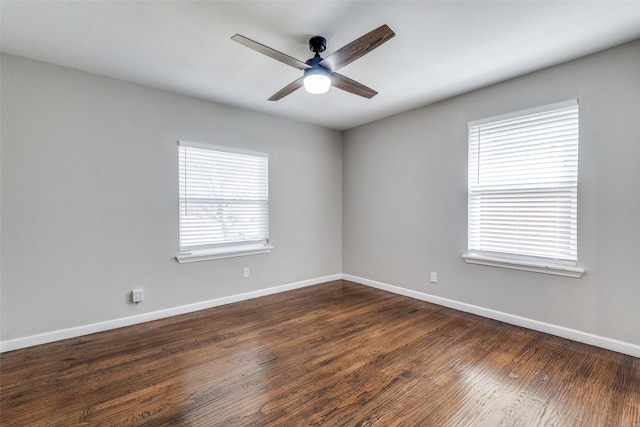 empty room with dark wood-type flooring, ceiling fan, and baseboards