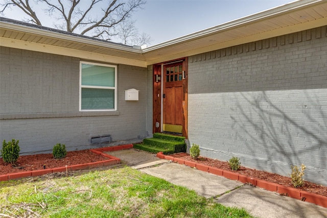 entrance to property featuring brick siding