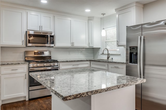 kitchen with white cabinets, decorative backsplash, appliances with stainless steel finishes, dark wood-style flooring, and a sink