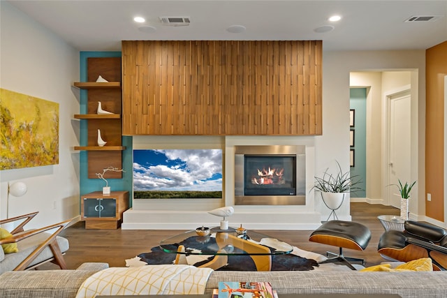 living room featuring recessed lighting, visible vents, dark wood-style floors, and a glass covered fireplace