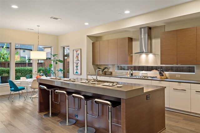 636 Benalla Dr, Frisco, TX 75036 - kitchen featuring wall chimney range hood, modern cabinets, wood finished floors, and recessed lighting