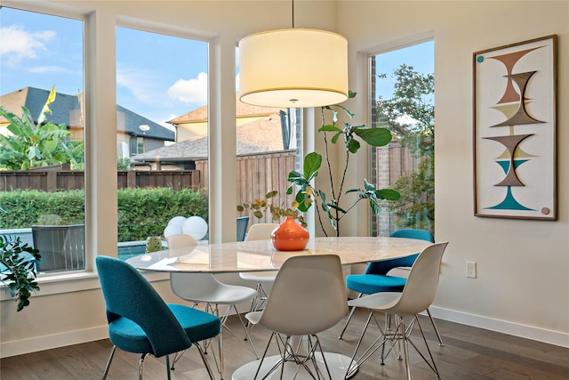 dining area with baseboards and wood finished floors