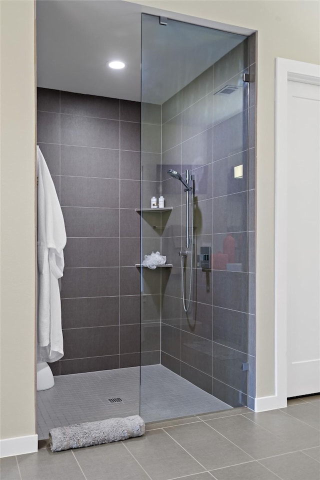 full bath featuring baseboards, walk in shower, and tile patterned flooring