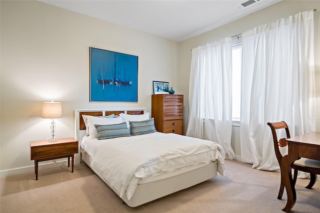 bedroom with light carpet, visible vents, and baseboards