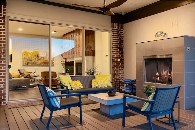 wooden terrace featuring ceiling fan and an outdoor living space with a fireplace