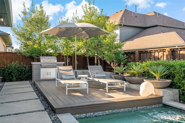 wooden terrace with grilling area and a fenced backyard