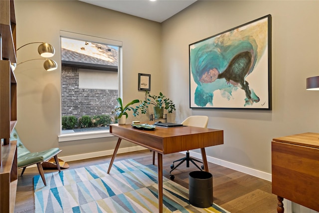 home office with baseboards and wood finished floors