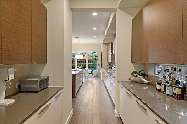 636 Benalla Dr, Frisco, TX 75036 - kitchen featuring modern cabinets, light wood-type flooring, brown cabinets, and recessed lighting