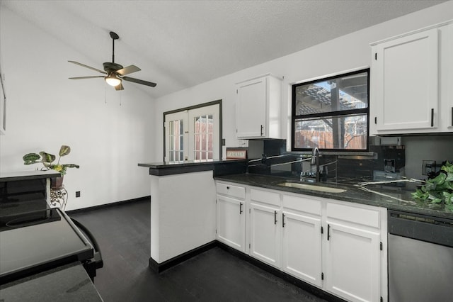 kitchen with a sink, lofted ceiling, stainless steel dishwasher, and white cabinets