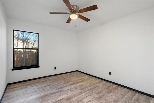 unfurnished room featuring baseboards, light wood-style floors, and ceiling fan