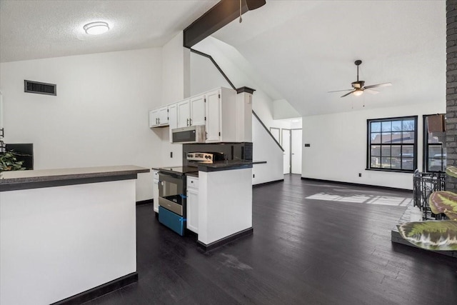 kitchen featuring dark countertops, visible vents, electric range, white cabinetry, and stainless steel microwave