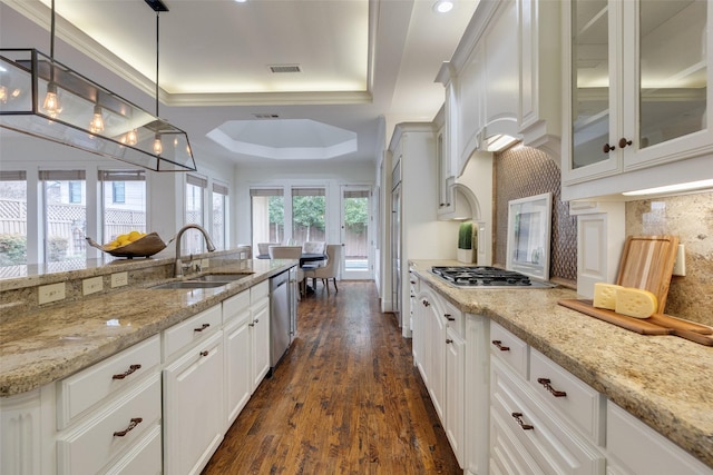 kitchen with dark wood-style floors, a raised ceiling, visible vents, white cabinetry, and a sink