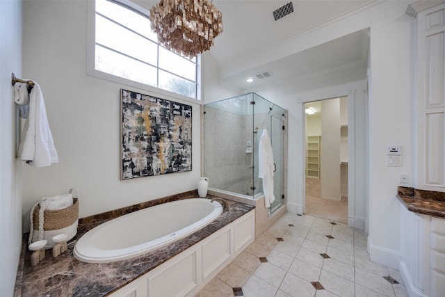 bathroom featuring a garden tub, a shower stall, visible vents, and a walk in closet