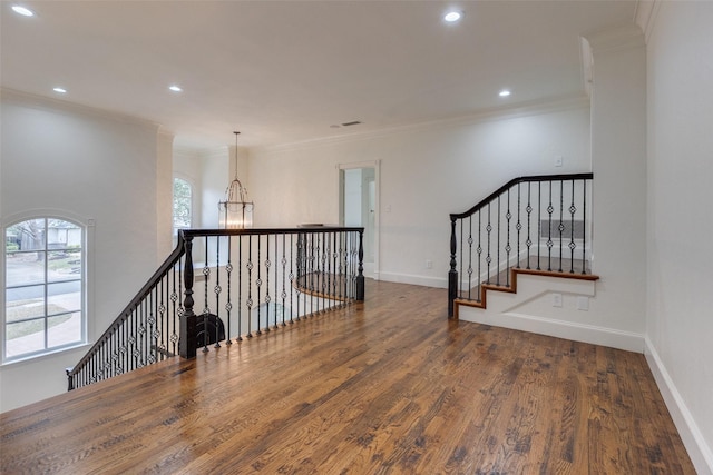 interior space featuring baseboards, ornamental molding, wood finished floors, and recessed lighting