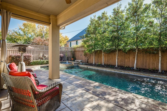 view of pool featuring a patio area, a fenced backyard, and a pool with connected hot tub