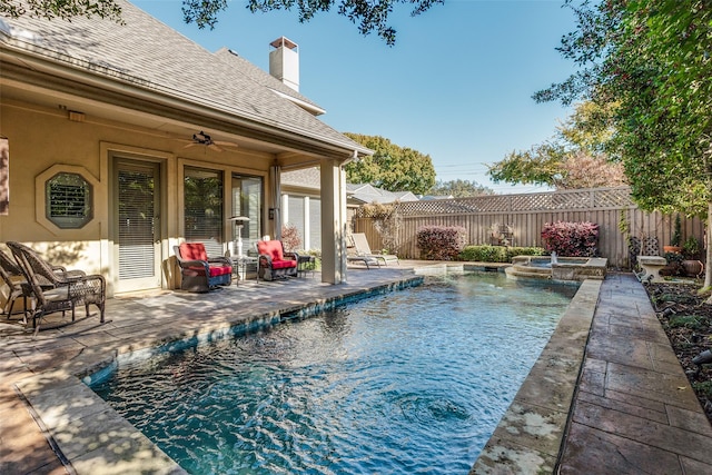 view of pool featuring a fenced backyard, a pool with connected hot tub, a ceiling fan, and a patio