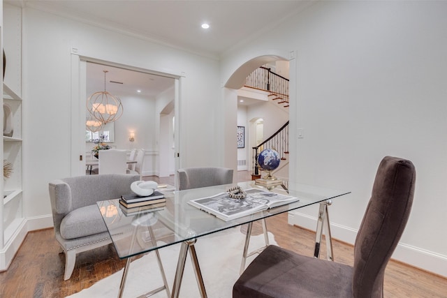 dining area with arched walkways, crown molding, wood finished floors, a chandelier, and stairs