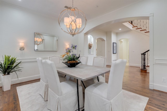 dining space with ornamental molding, arched walkways, visible vents, and wood finished floors