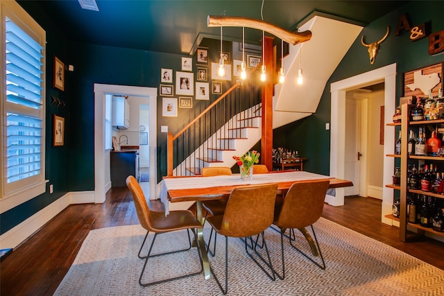 dining room featuring stairway, baseboards, and wood-type flooring