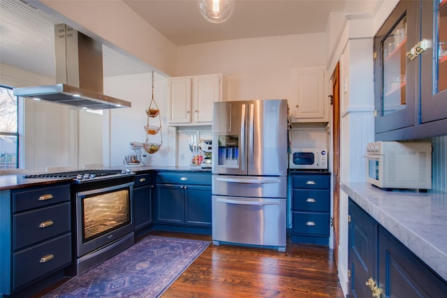 kitchen featuring dark wood finished floors, island exhaust hood, white cabinets, stainless steel appliances, and blue cabinets