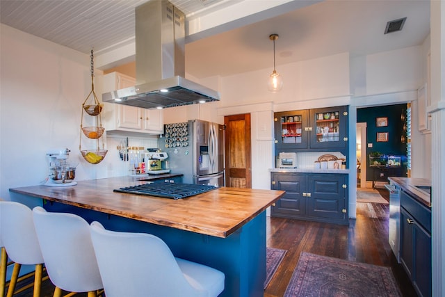 kitchen featuring visible vents, dark wood-type flooring, appliances with stainless steel finishes, a peninsula, and island range hood