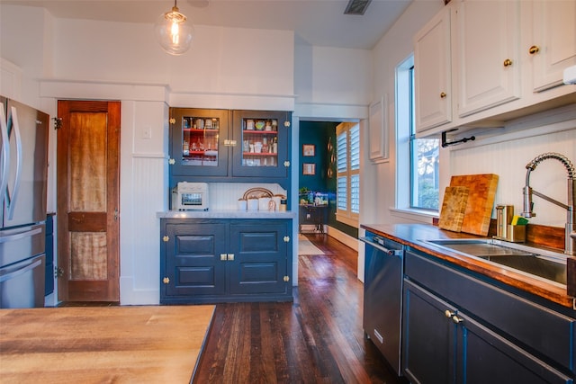 kitchen featuring dark wood-style floors, a sink, white cabinets, glass insert cabinets, and appliances with stainless steel finishes